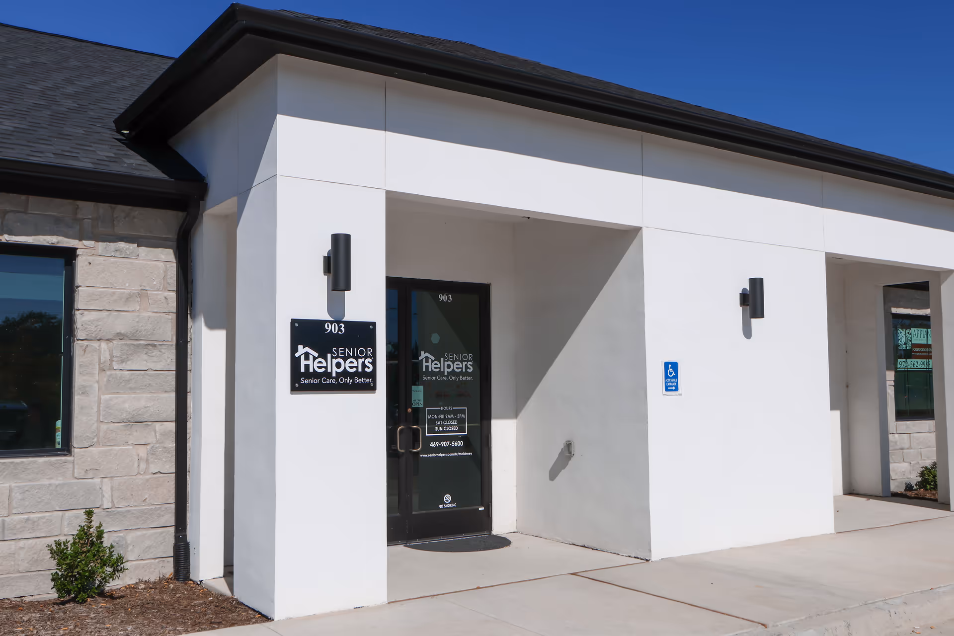 White exterior of Senior Helpers facility with entrance door and handicap sign.