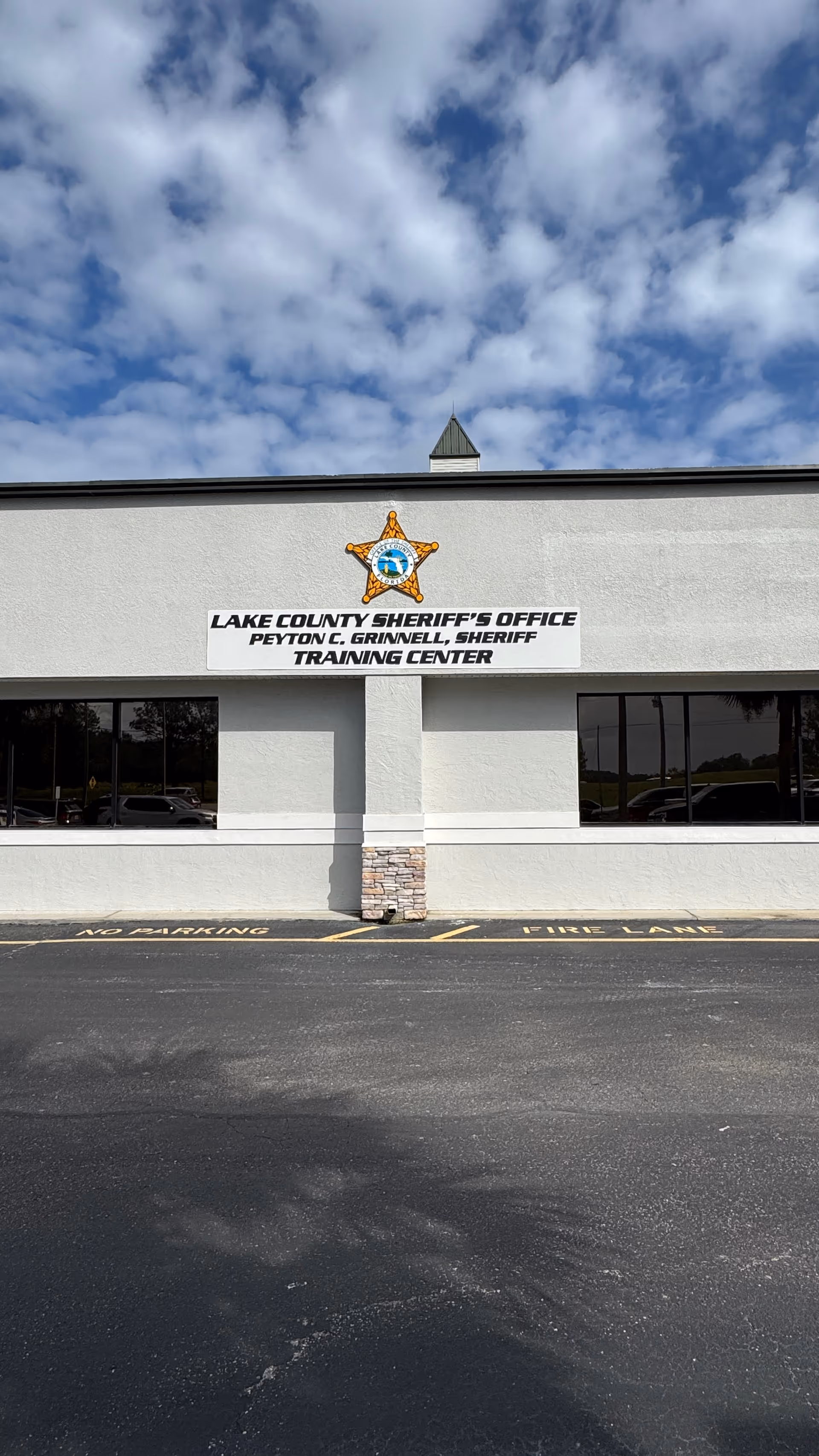 Front exterior of a building with sheriff's office sign and emblem.