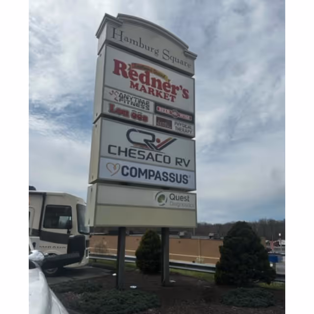 Tall outdoor sign at Hamburg Square listing Compassus among other tenants.