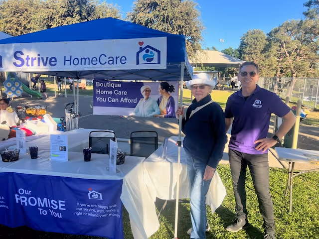 Outdoor Strive HomeCare booth with staff members at a community health event.