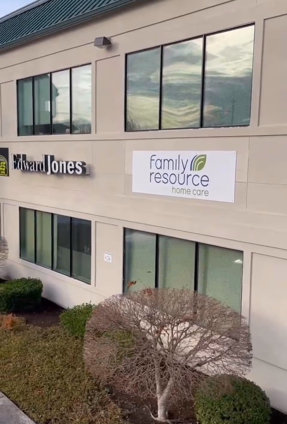 Exterior view of a beige building with Family resource home care and Edward Jones signs.