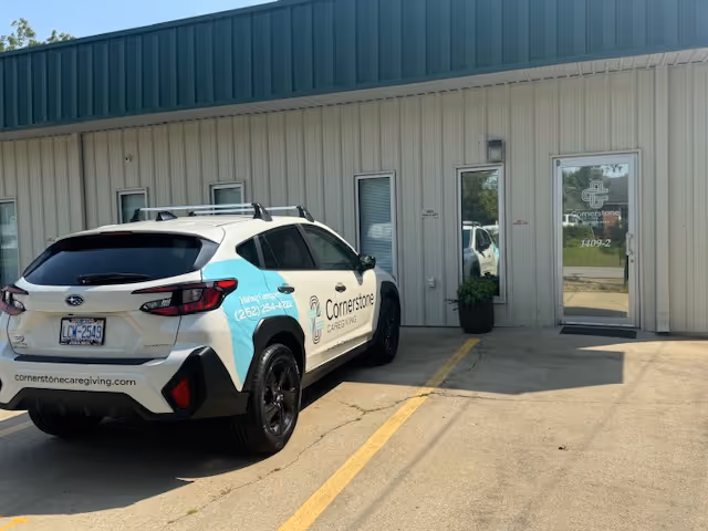 Exterior view of Cornerstone Caregiving building with a branded car parked in front
