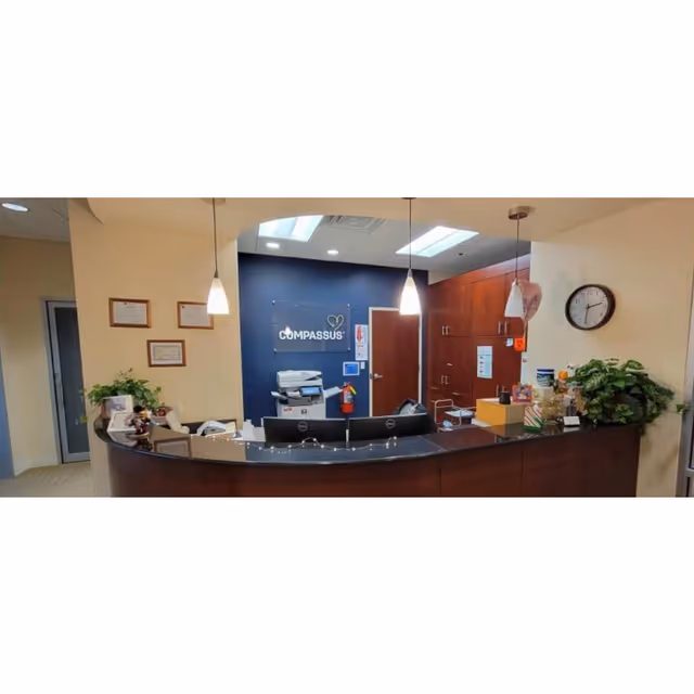Reception desk in a Compassus facility lobby with blue wall and cabinets.