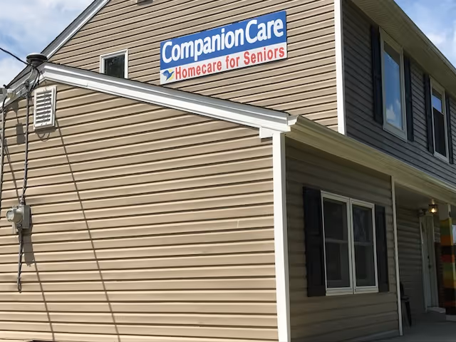Exterior view of a tan building with a blue Companion Care sign reading Homecare for Seniors.
