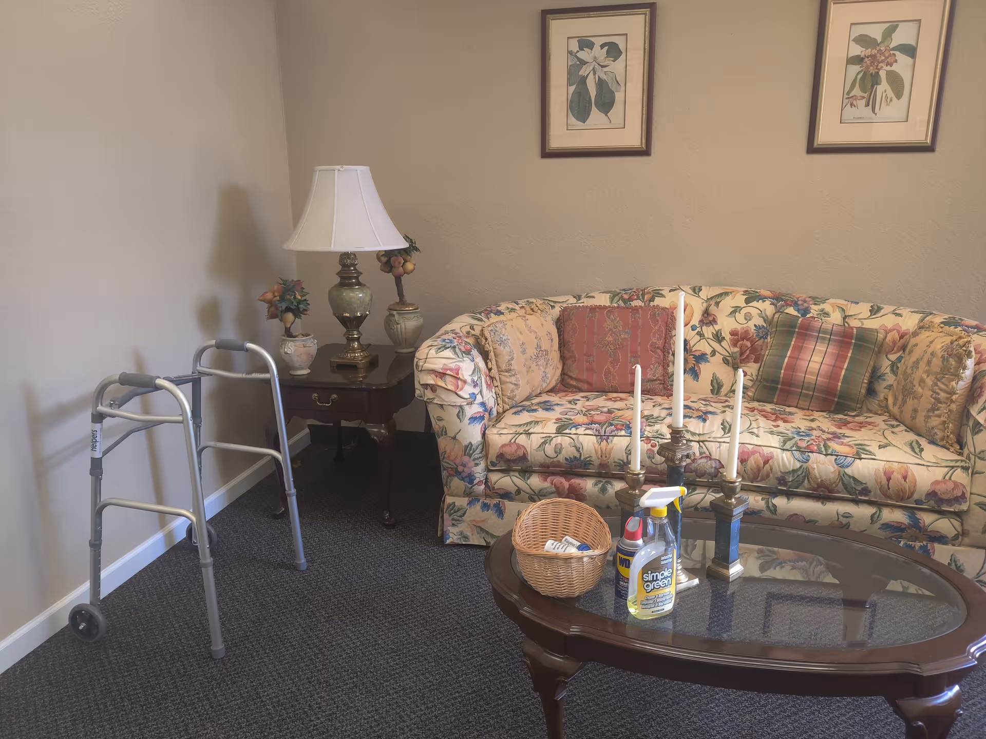 Floral sofa and coffee table in a cozy living room with a walker nearby.