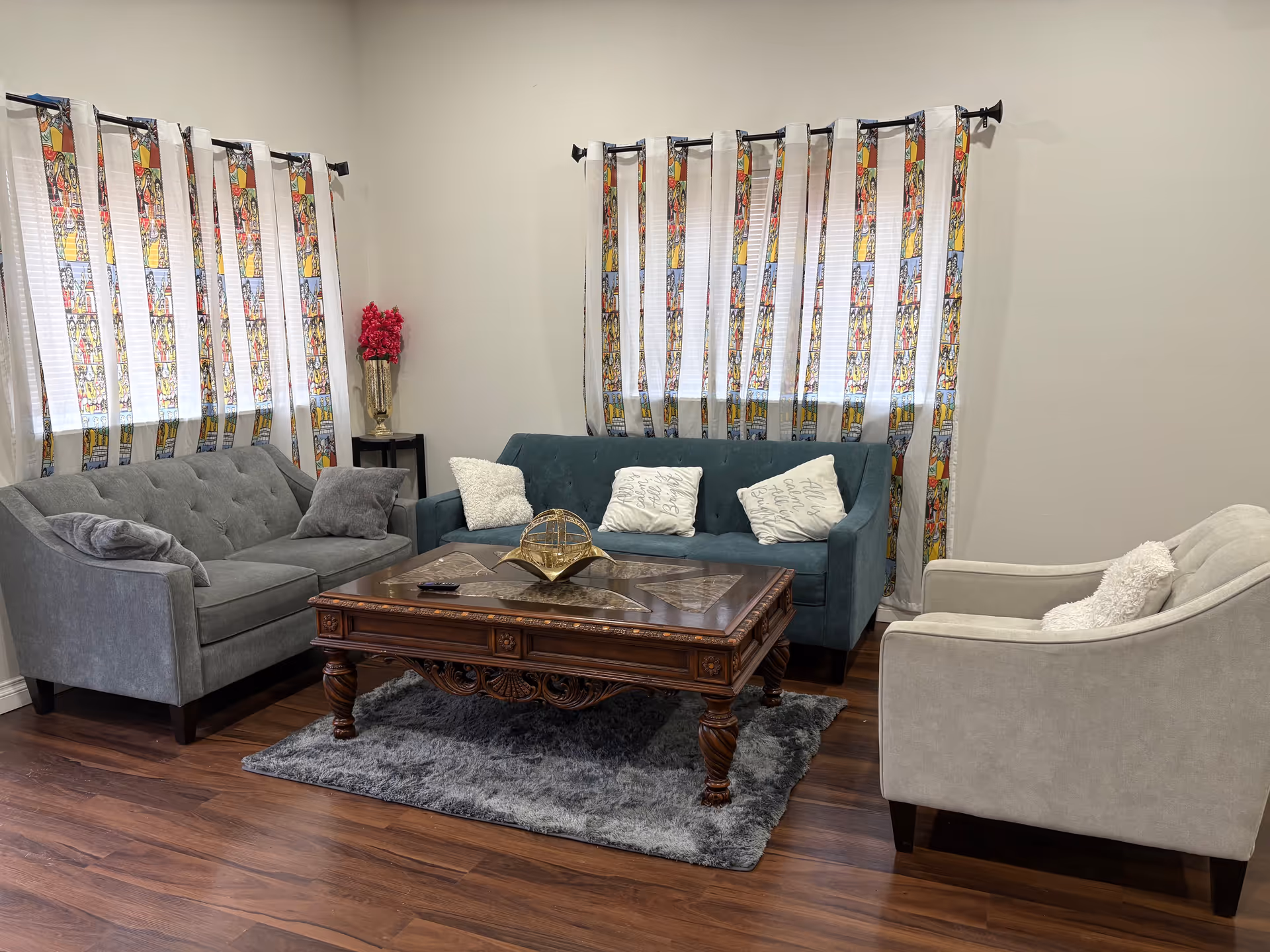 A cozy living room in a senior facility with three sofas around a wooden coffee table.