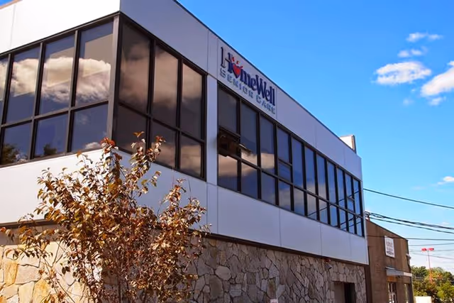 Two-story modern building with large windows and HomeWell Care Services sign.