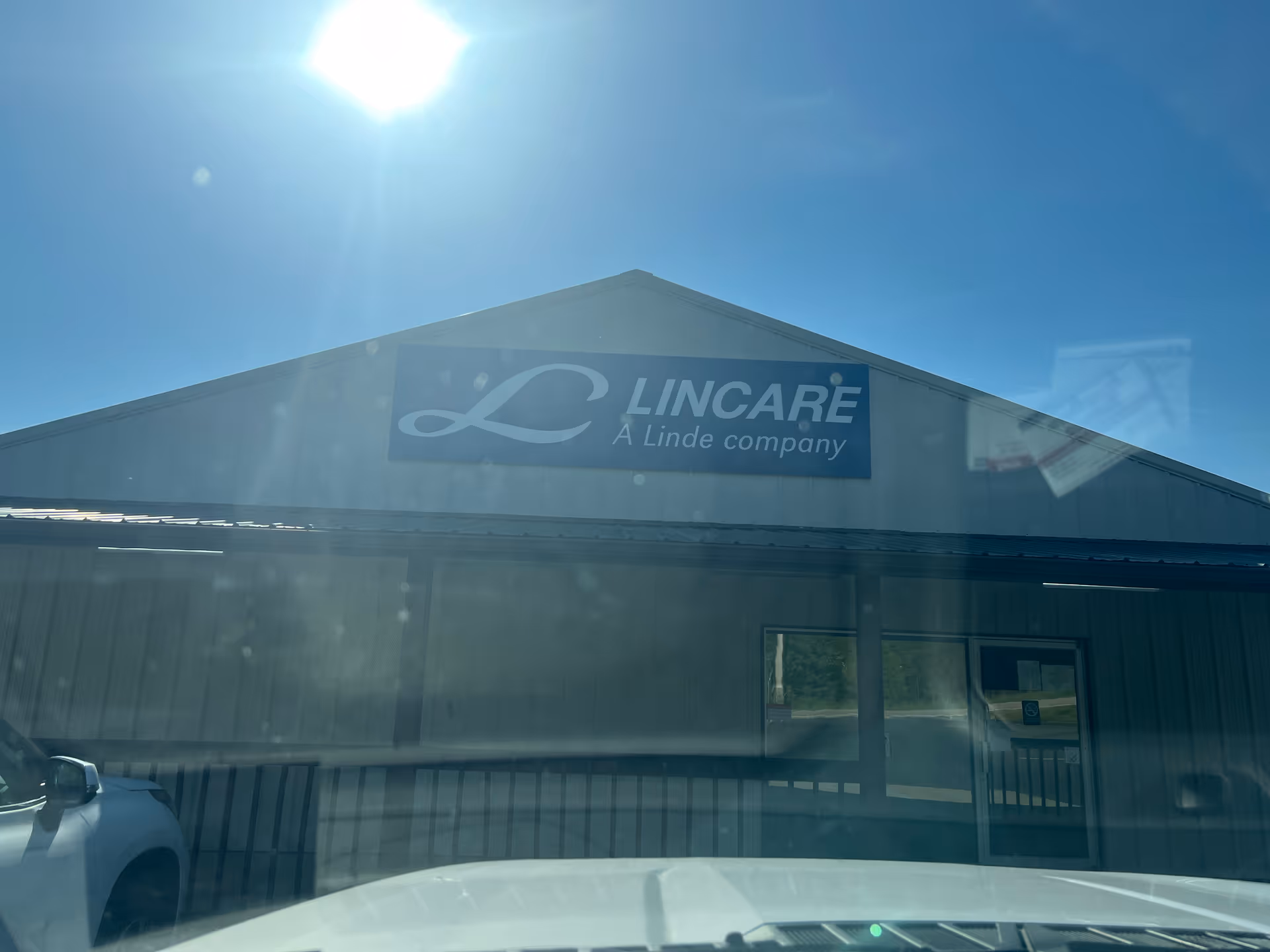 Exterior view of a LINCARE facility front with sign beneath a bright blue sky.