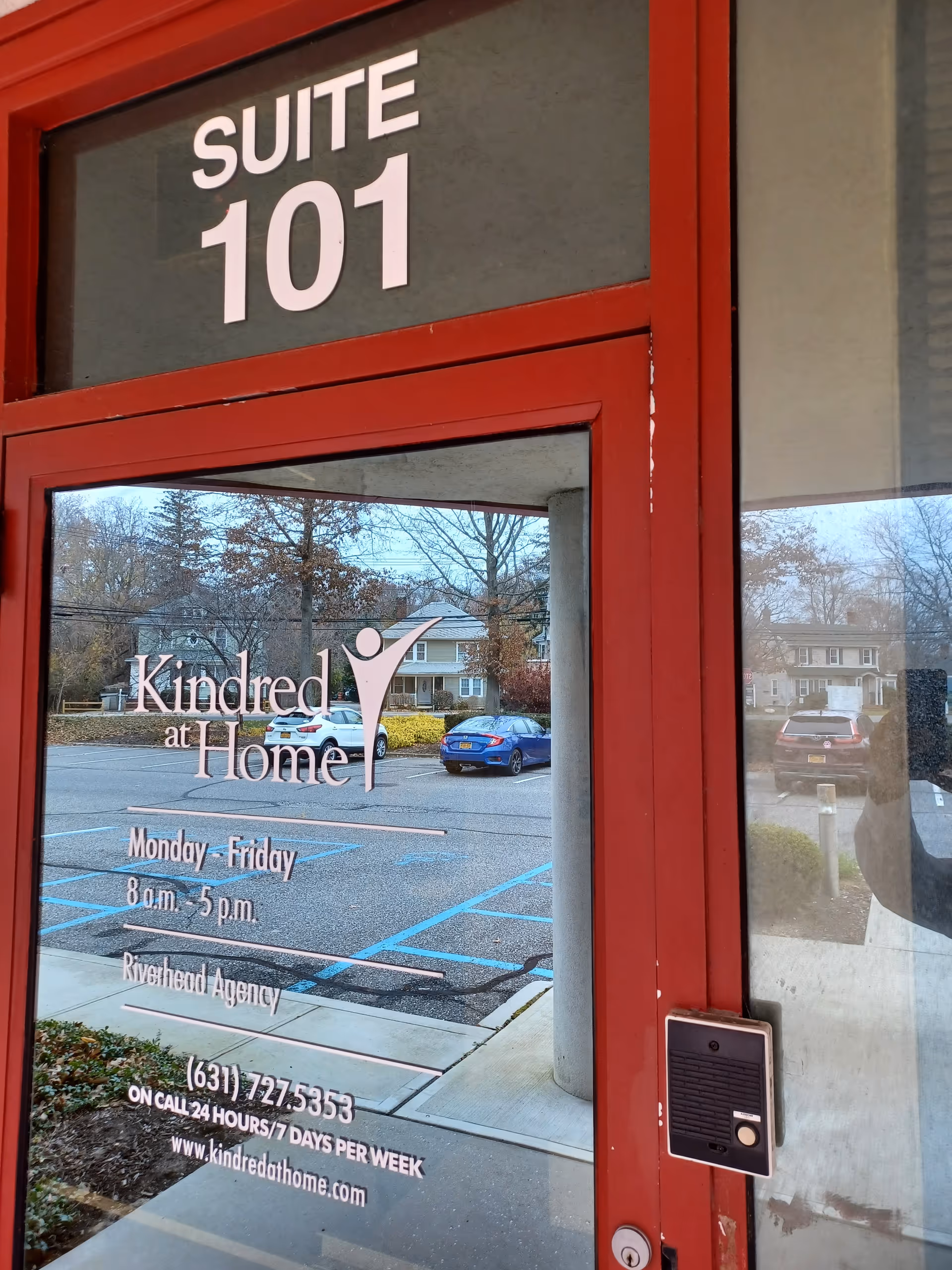 Red-framed glass door displaying Suite 101 and Kindred at Home signage.