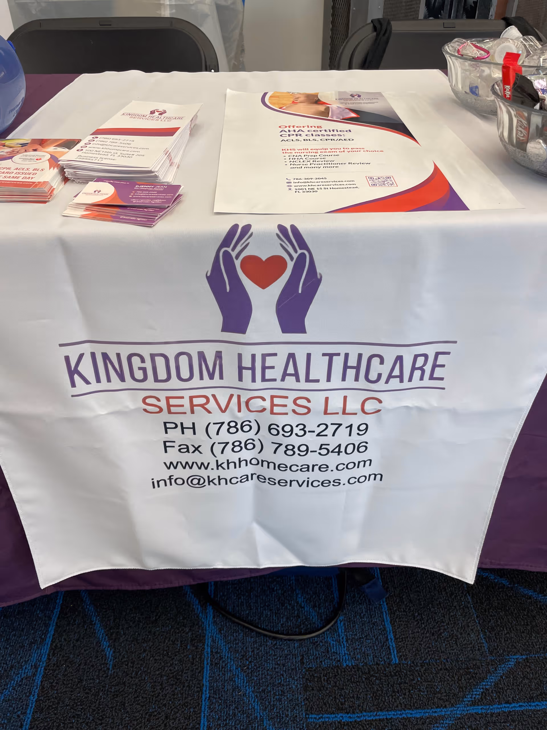 Indoor promotional table featuring Kingdom Healthcare Services LLC branding and brochures.