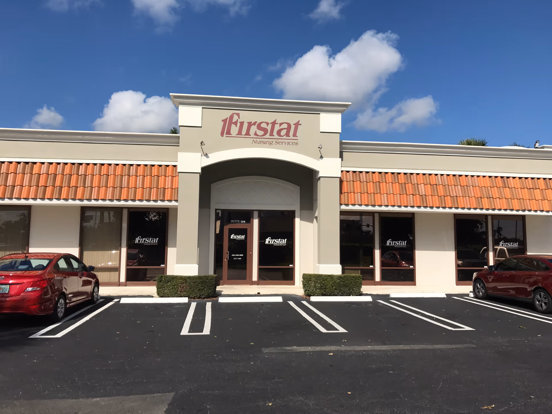 Exterior view of Firstat Nursing Services building with red-tiled roof and parking lot.