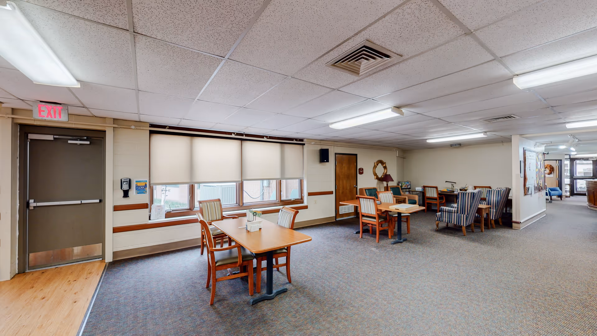 A spacious indoor common area with tables, chairs, and lounge seating.