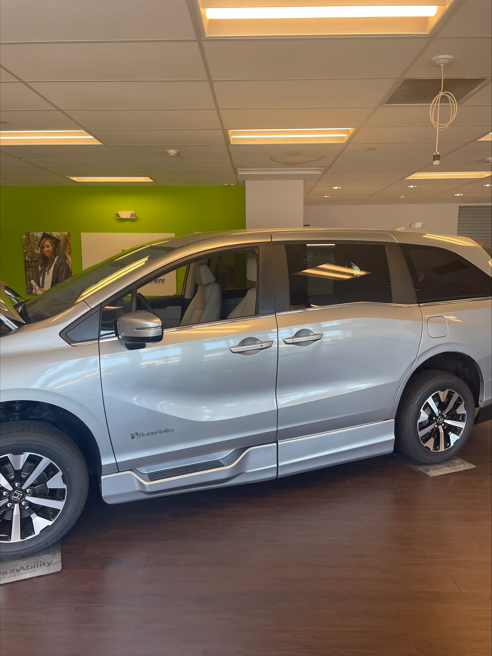 A silver minivan displayed indoors in a MobilityWorks showroom.