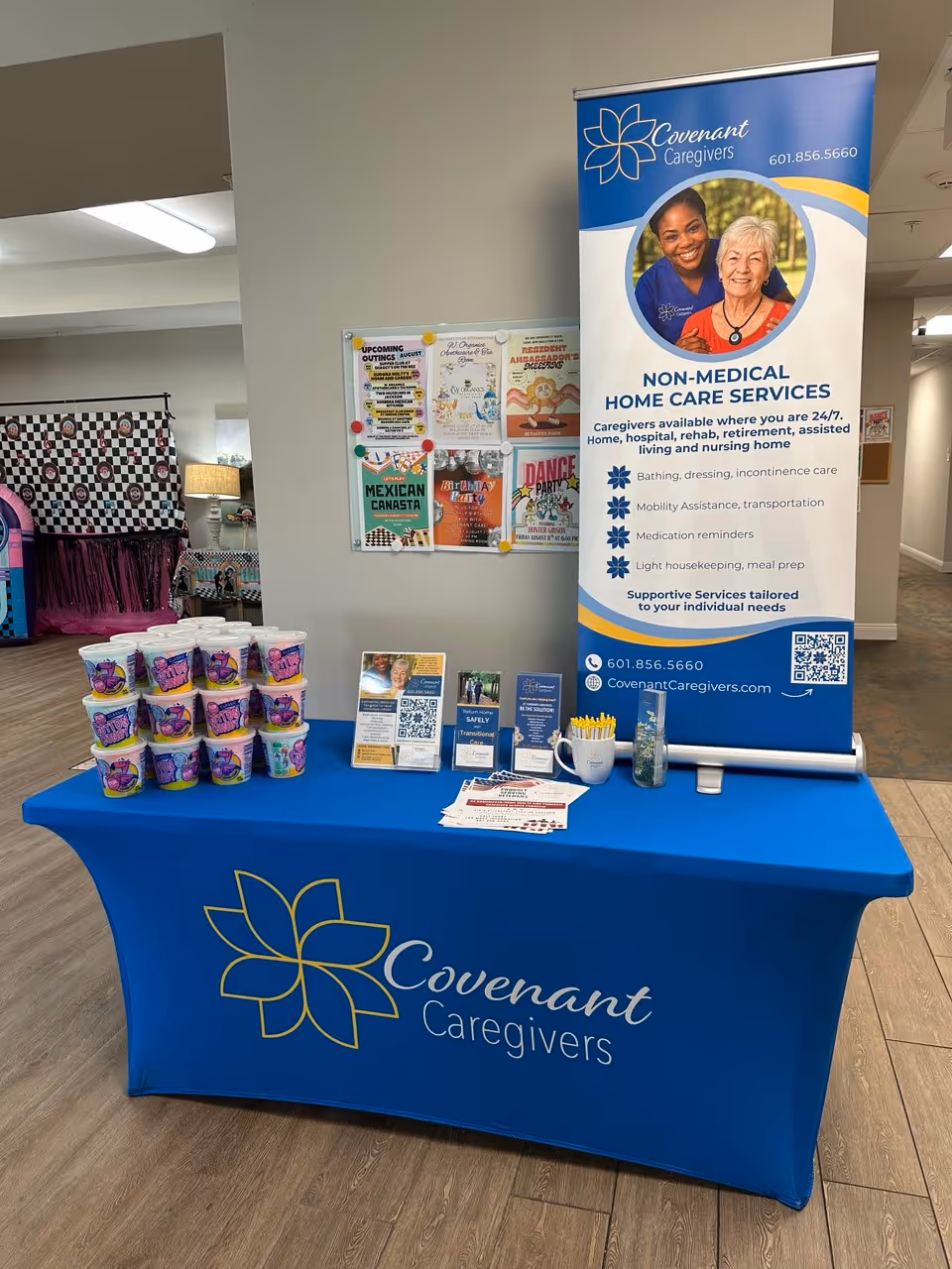Blue Covenant Caregivers table with banner and brochures in a lobby.