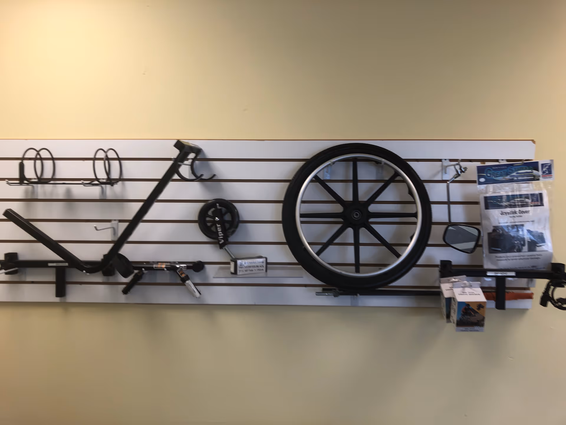 Mounted wall display of a disassembled bicycle with wheel, frame, and accessories.