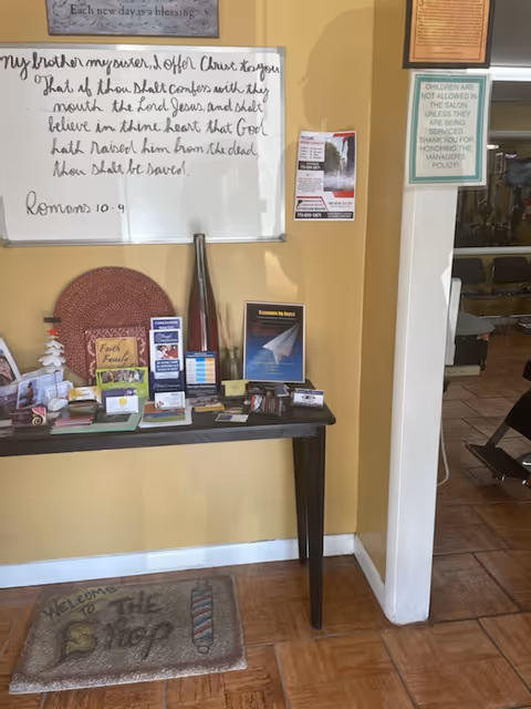 Interior hallway with brochure table, whiteboard, and doorway to adjacent room.