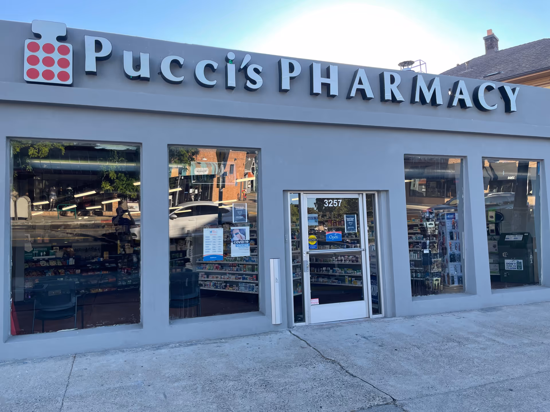 Front view of Pucci's Pharmacy storefront with large windows and a glass door.