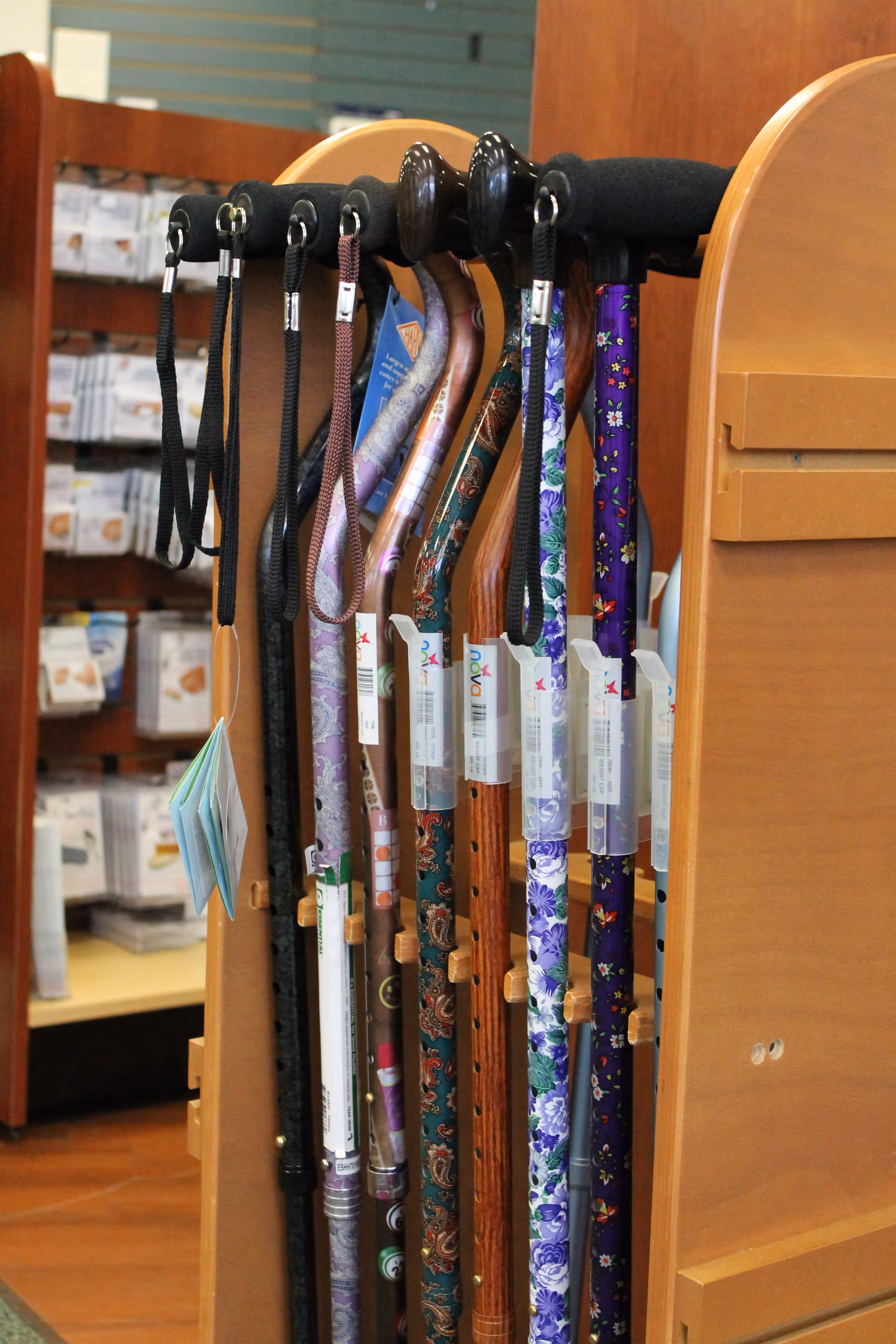 Indoor display rack with colorful patterned walking canes and tags.