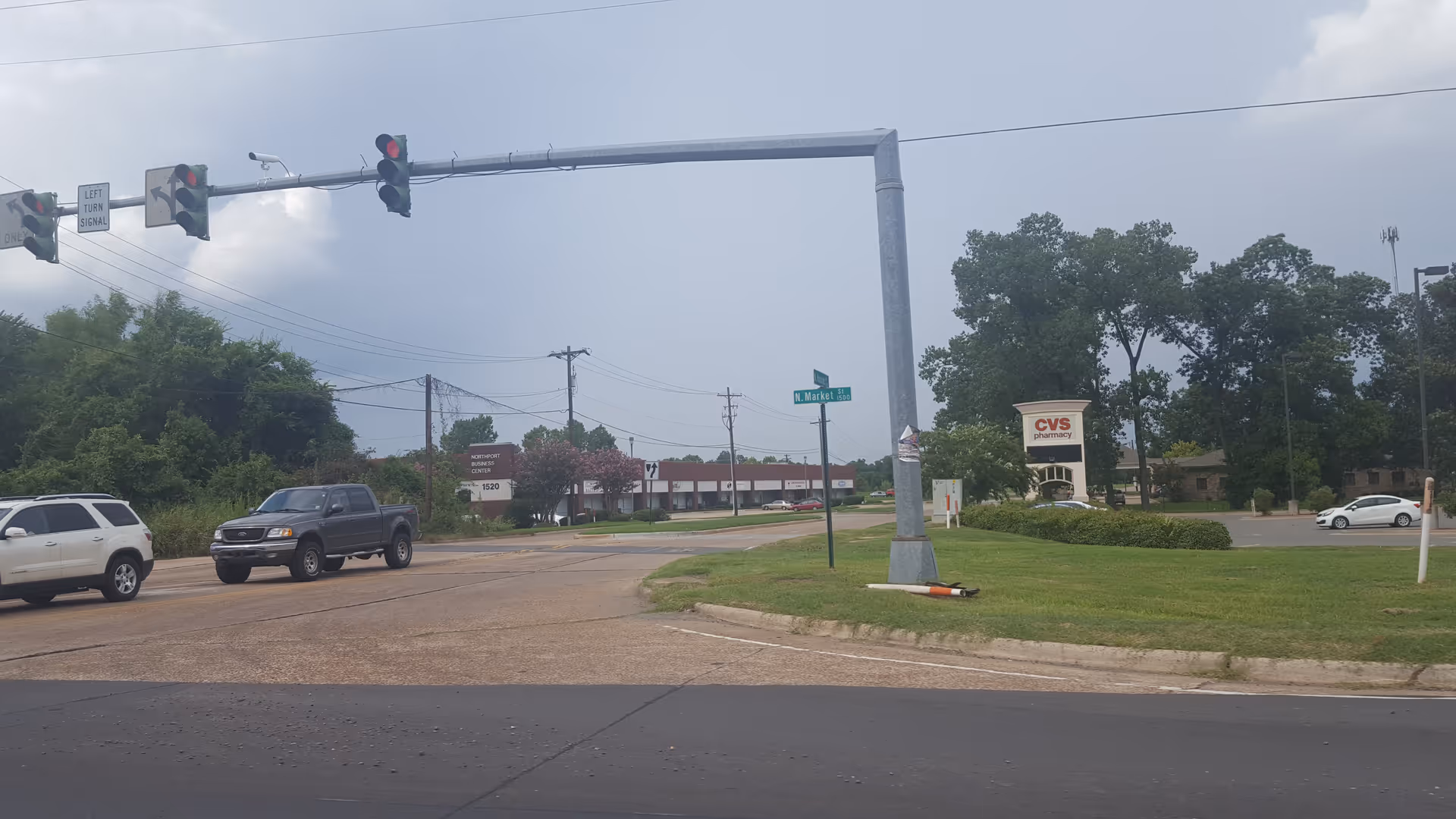Street intersection with traffic lights, grassy median, and a CVS pharmacy in the background.