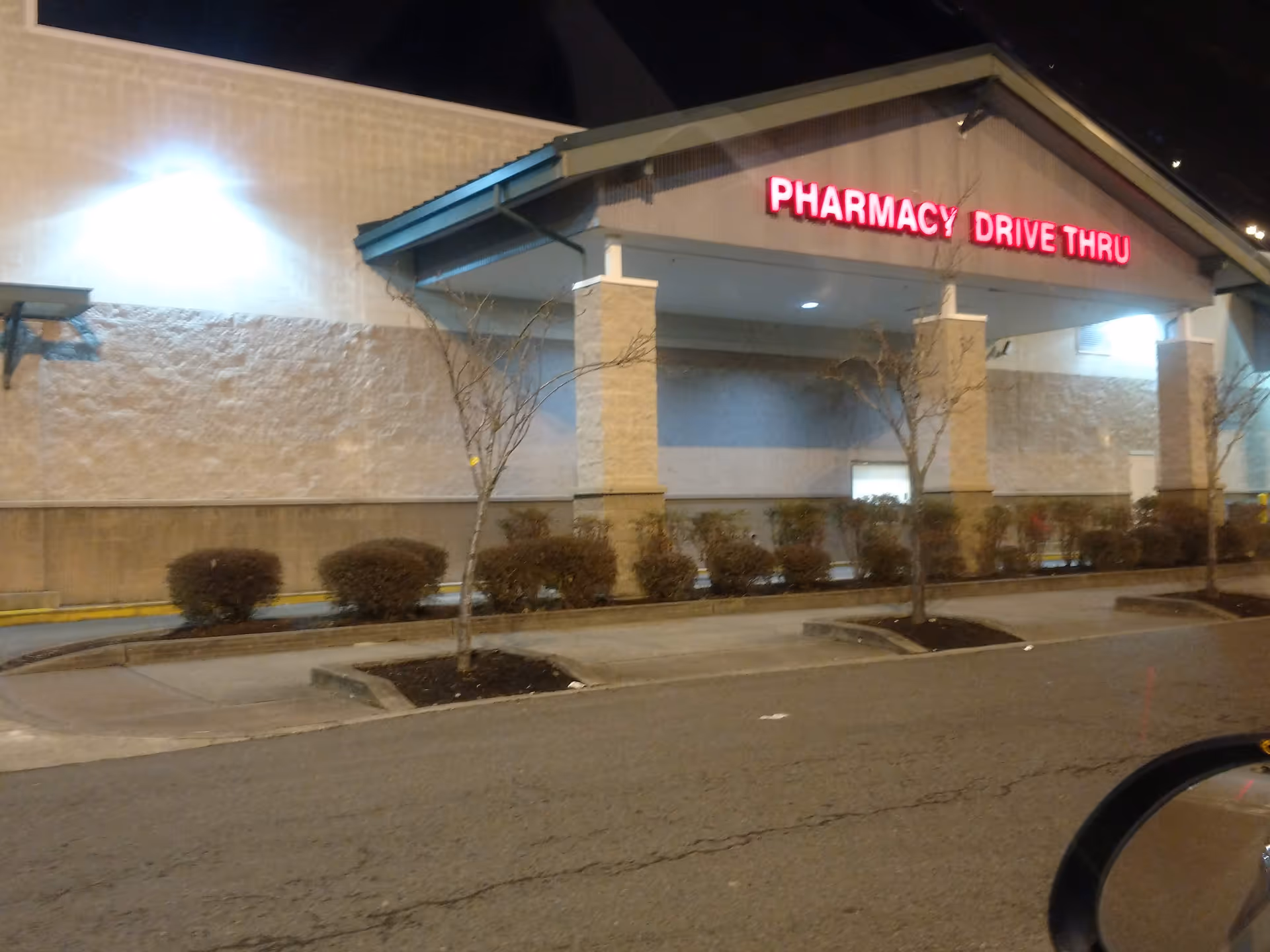 Exterior view of a building with a red PHARMACY DRIVE THRU sign.