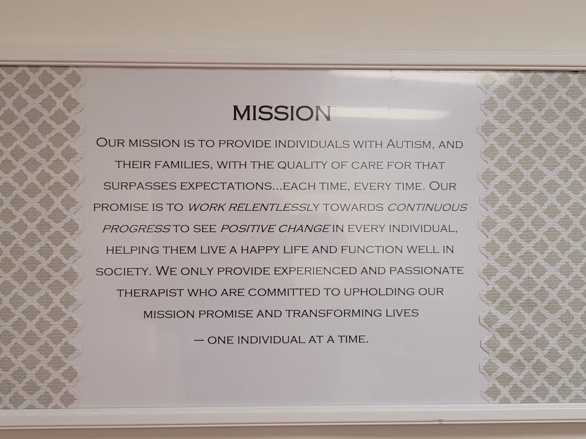 Large interior wall sign reading MISSION with a lengthy text, bordered by patterned wallpaper.