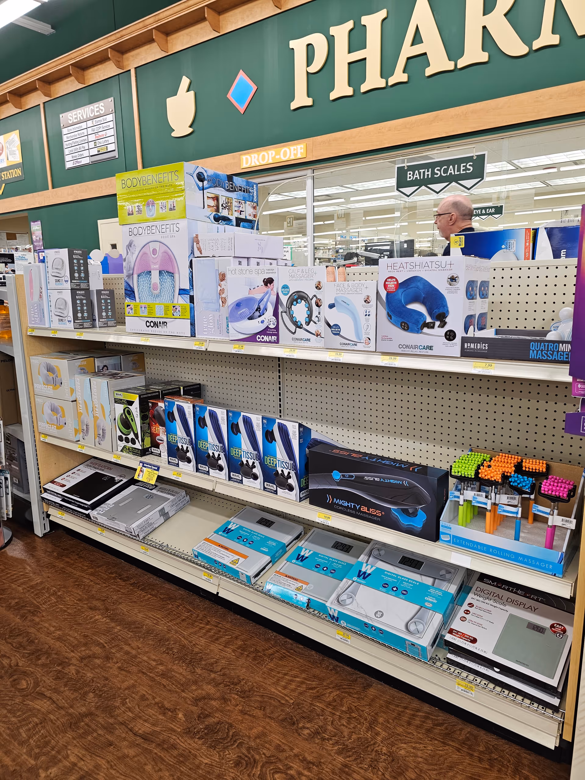 Discount drugstore aisle with shelves of medical devices and pharmacy signage.
