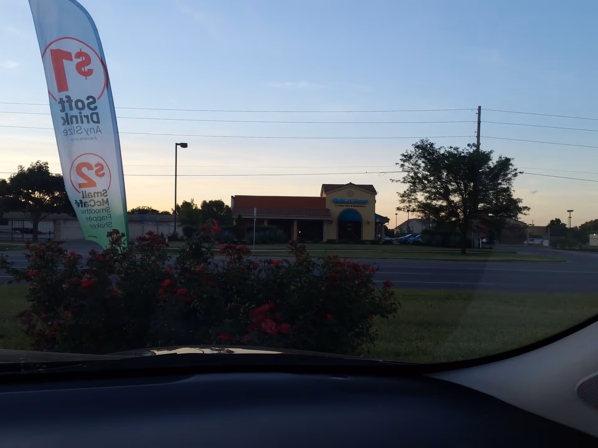 Exterior view of the Right at Home facility across the street with a flag and bushes