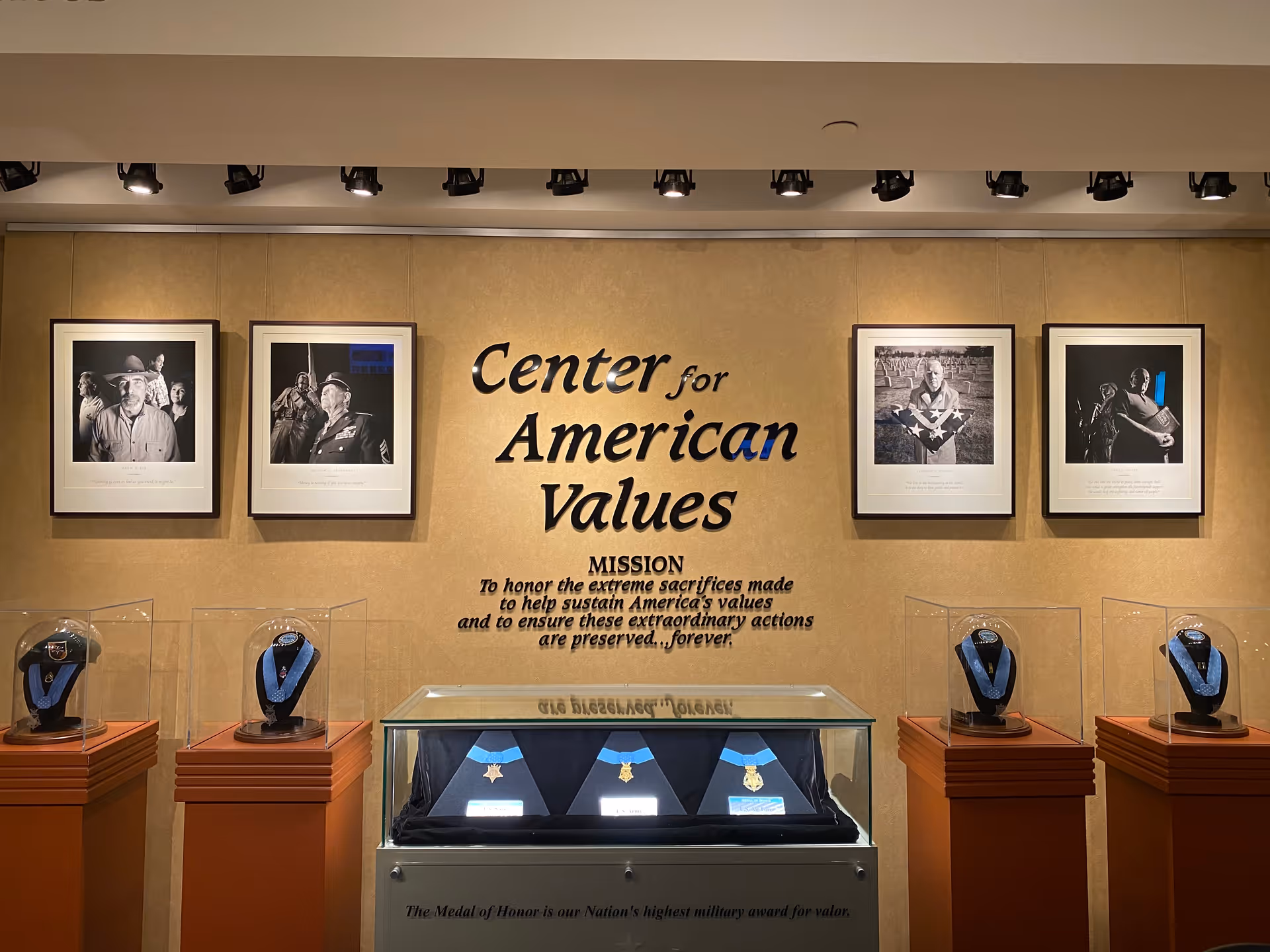 Gallery wall with framed photos and medal displays under Center for American Values.