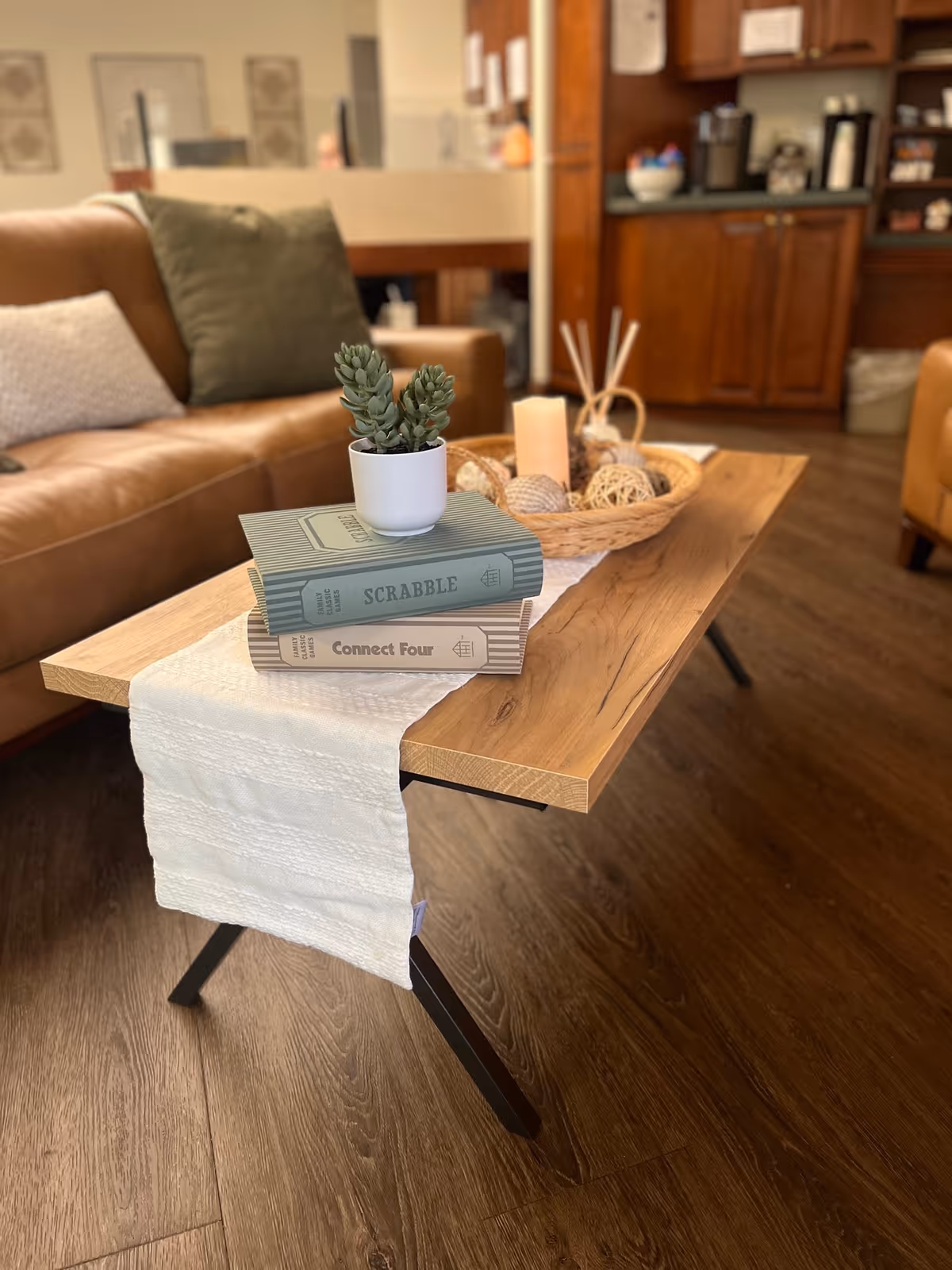 Cozy hospice lounge with a wooden coffee table, plant, books, and woven centerpiece.