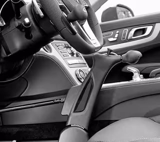 Close-up of a car interior showing steering wheel, gear shift, and control panels.