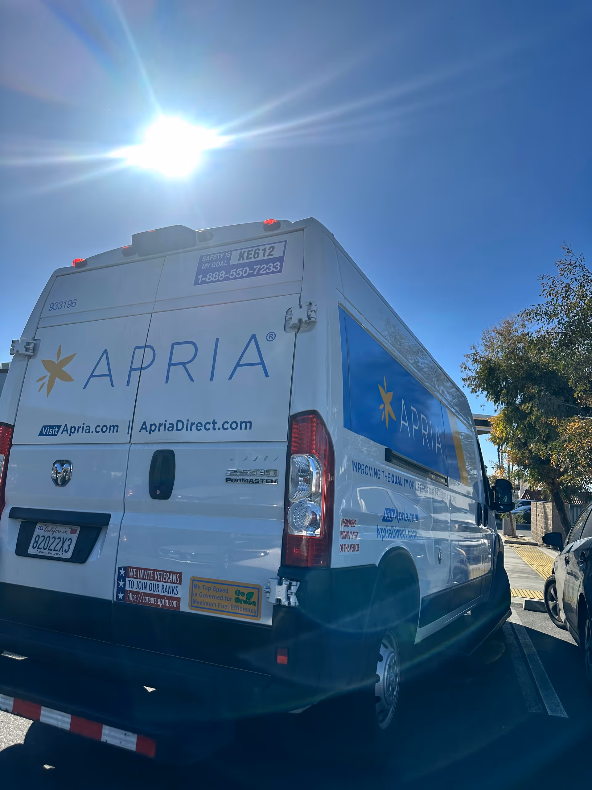 White Apria Healthcare delivery van parked outdoors with blue branding.
