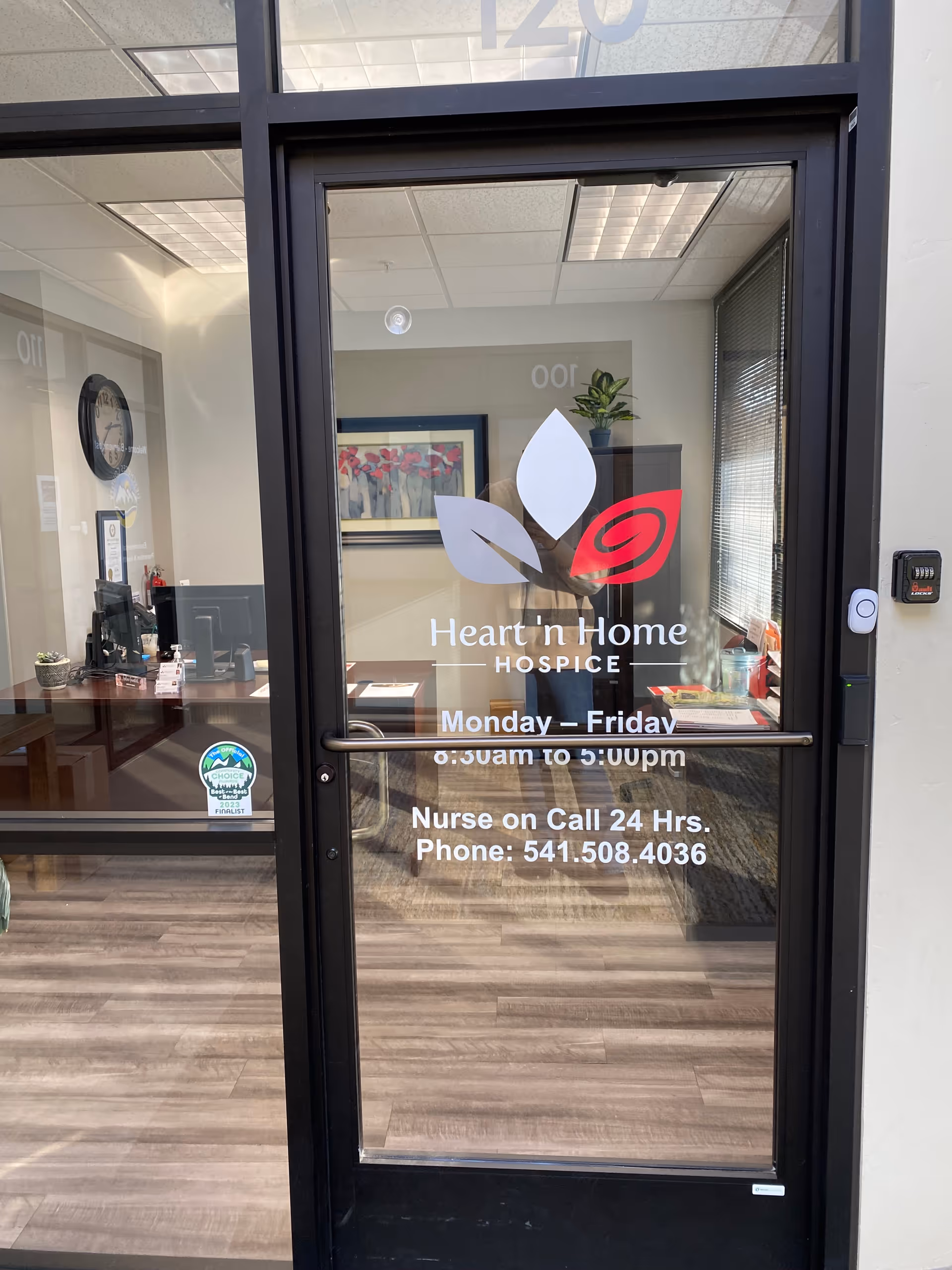 Glass door featuring Heart 'n Home Hospice logo; reception area visible inside.