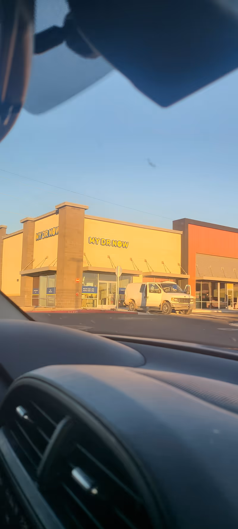 Exterior view of a MY DR NOW facility with a white van parked outside.