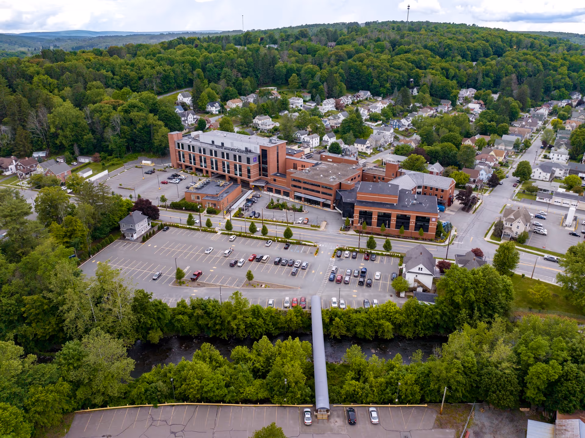 Aerial view of Wayne Memorial Hospital campus with parking and surrounding trees.