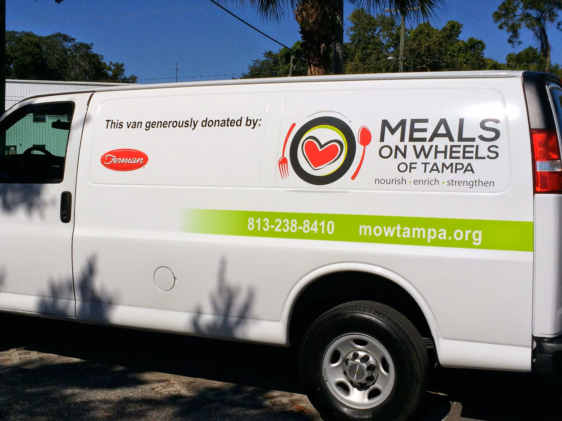 White Meals On Wheels of Tampa van parked outdoors with logo.