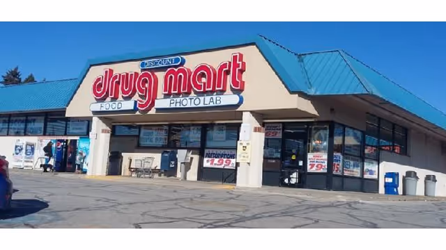 Storefront of Discount Drug Mart with a blue roof and a large Drug Mart sign.