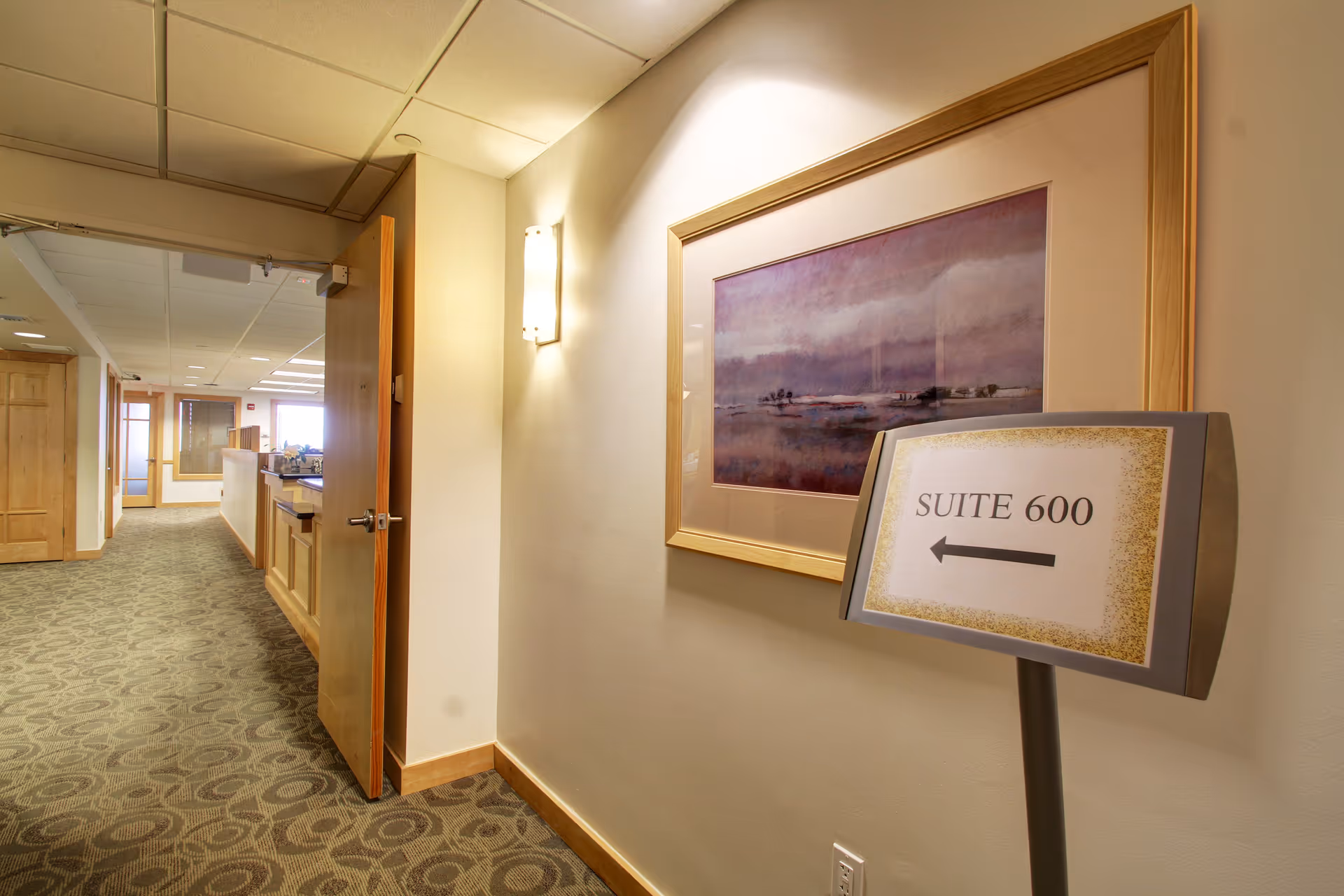 Interior hallway of a senior living facility with a Suite 600 sign and artwork