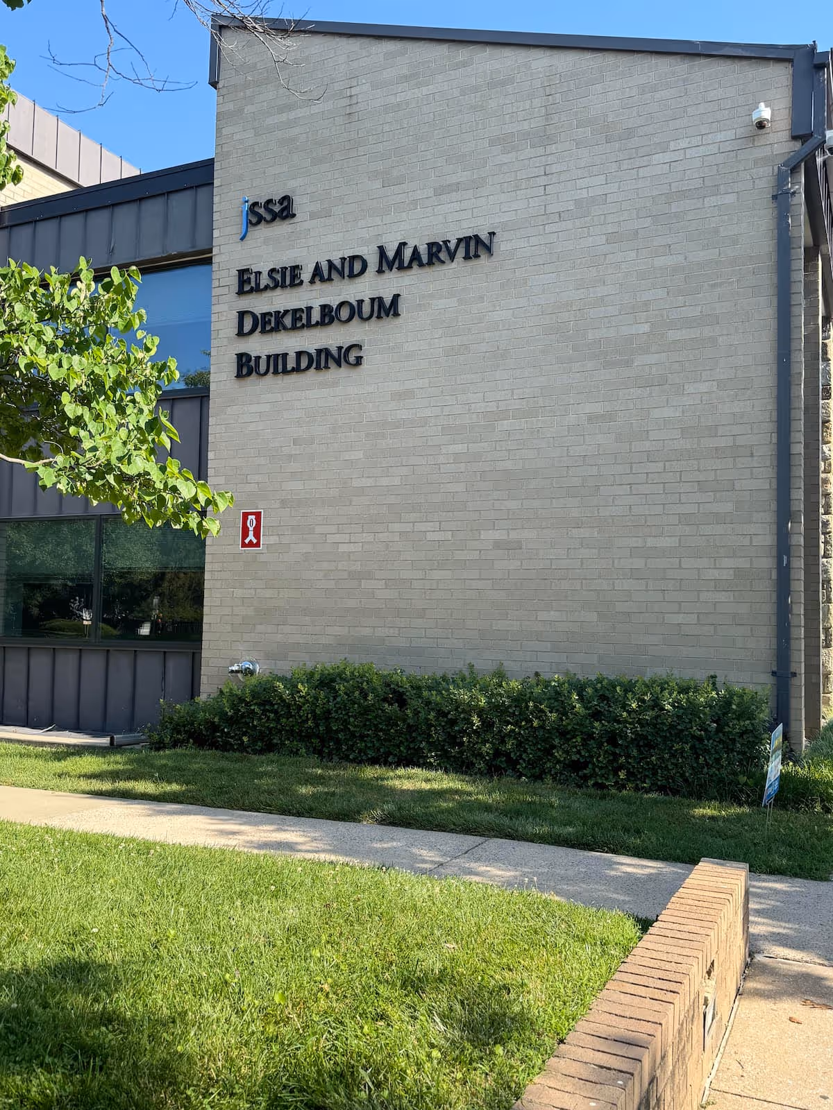 Exterior of the JSSA Elise and Marvin Dekelboum Building with surrounding greenery.
