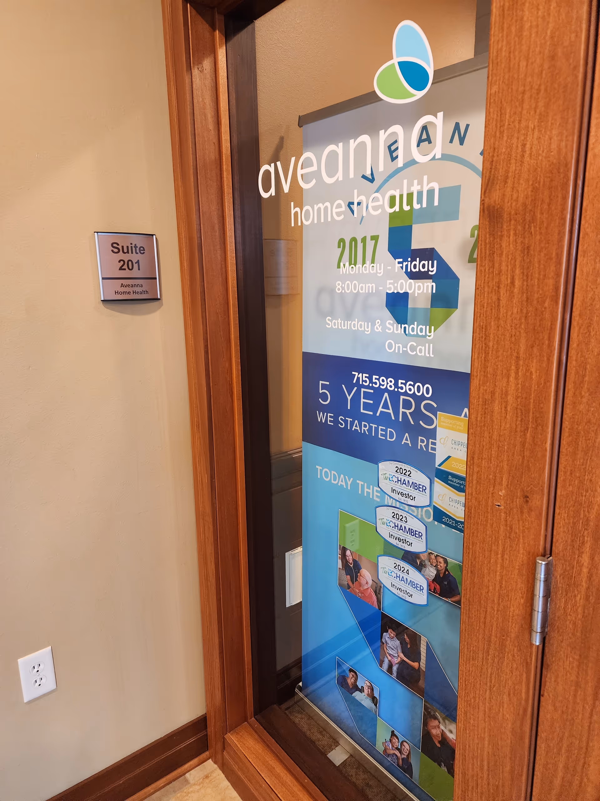 Doorway with Aveanna Home Health poster and Suite 201 sign in hallway