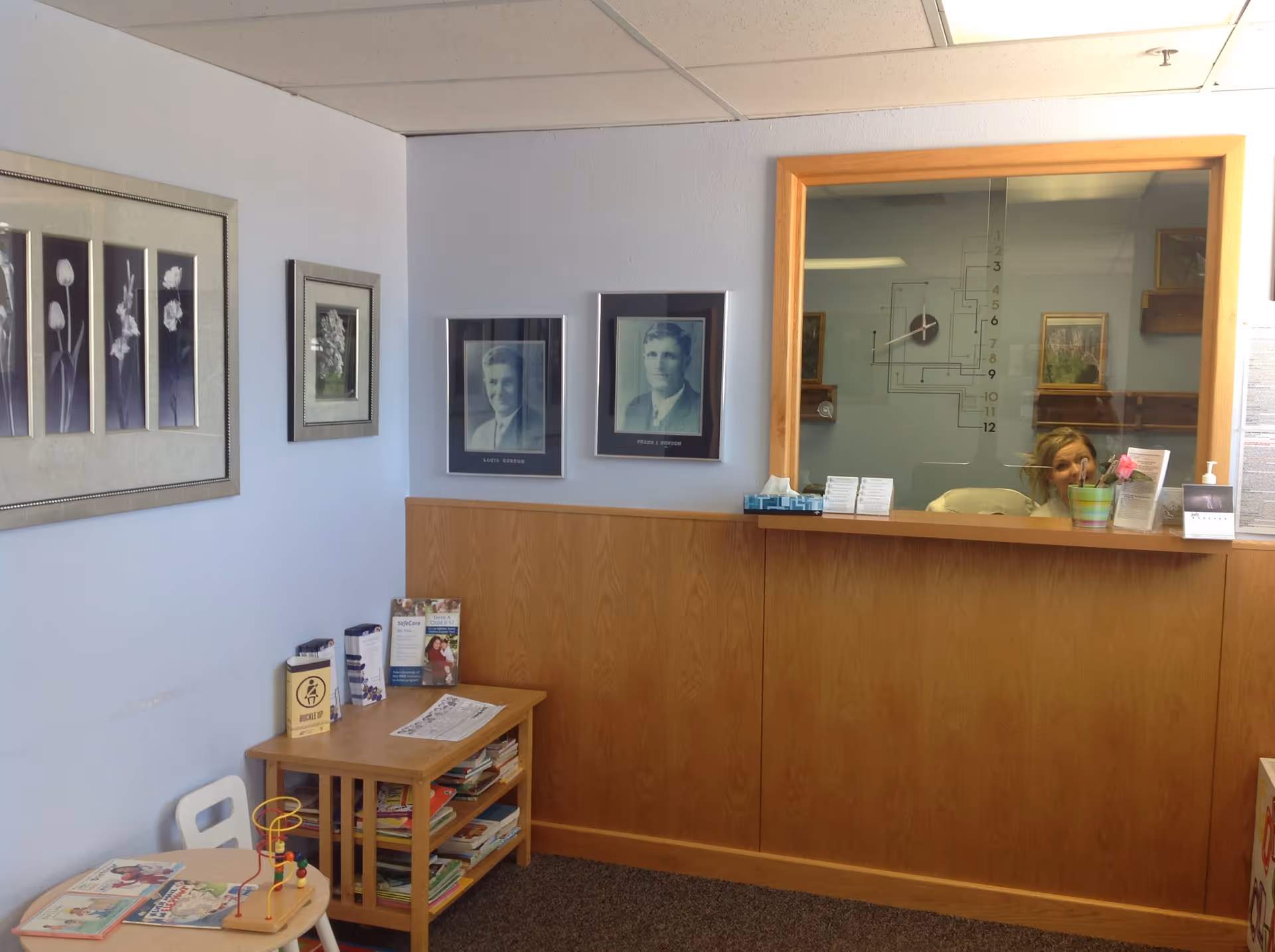 Reception area with wooden front desk and wall portraits inside Lincoln Health Community Hospital.