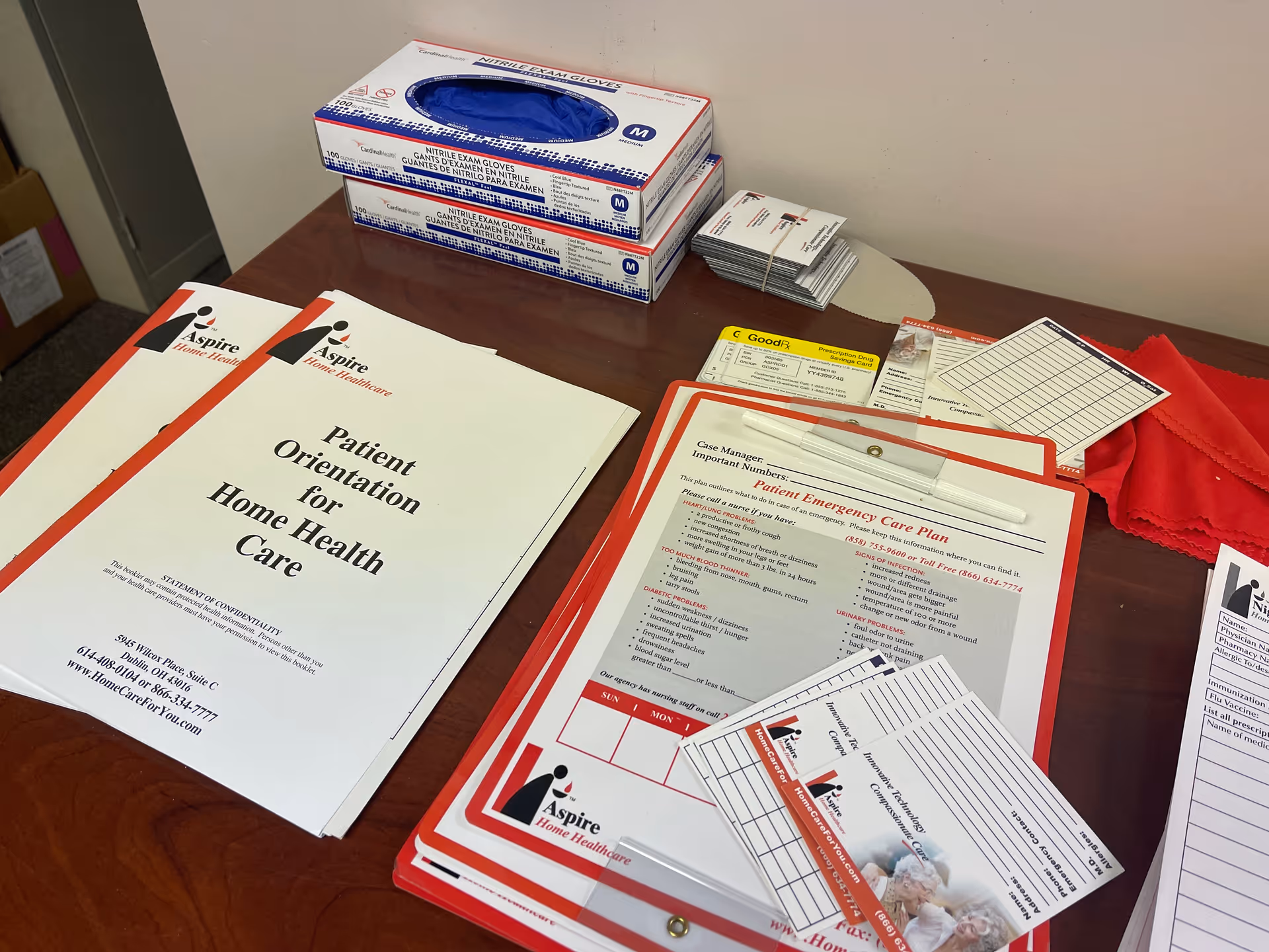 Desk with Aspire Home Healthcare forms, gloves, clipboards, and patient care paperwork.