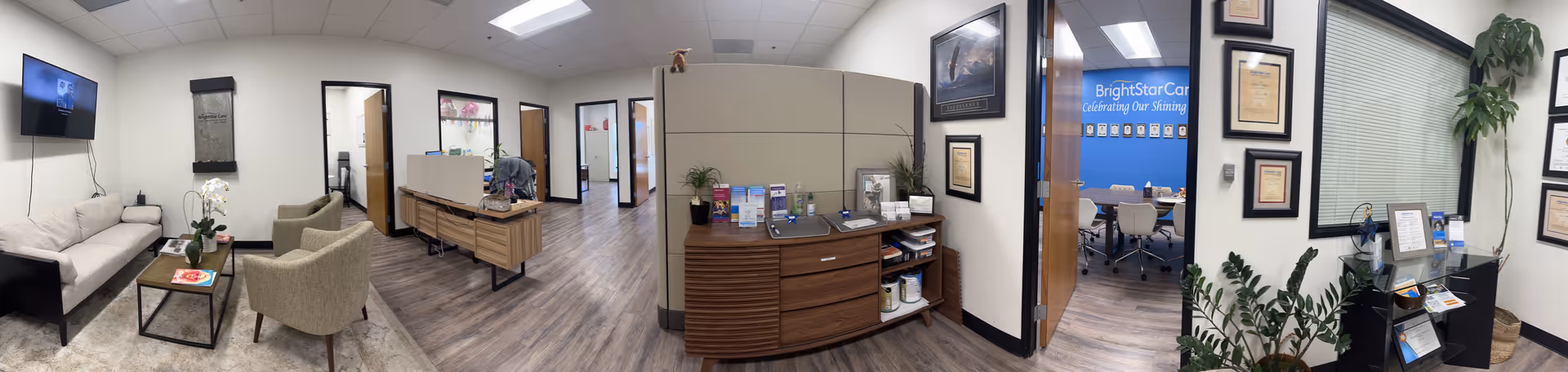 Panoramic interior view of a BrightStar Care lobby with seating, desks, and a reception area.