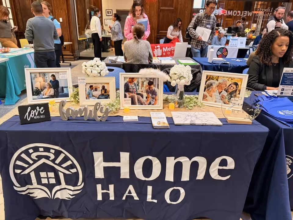 Indoor expo booth for Home Halo with framed photos and flowers on a table