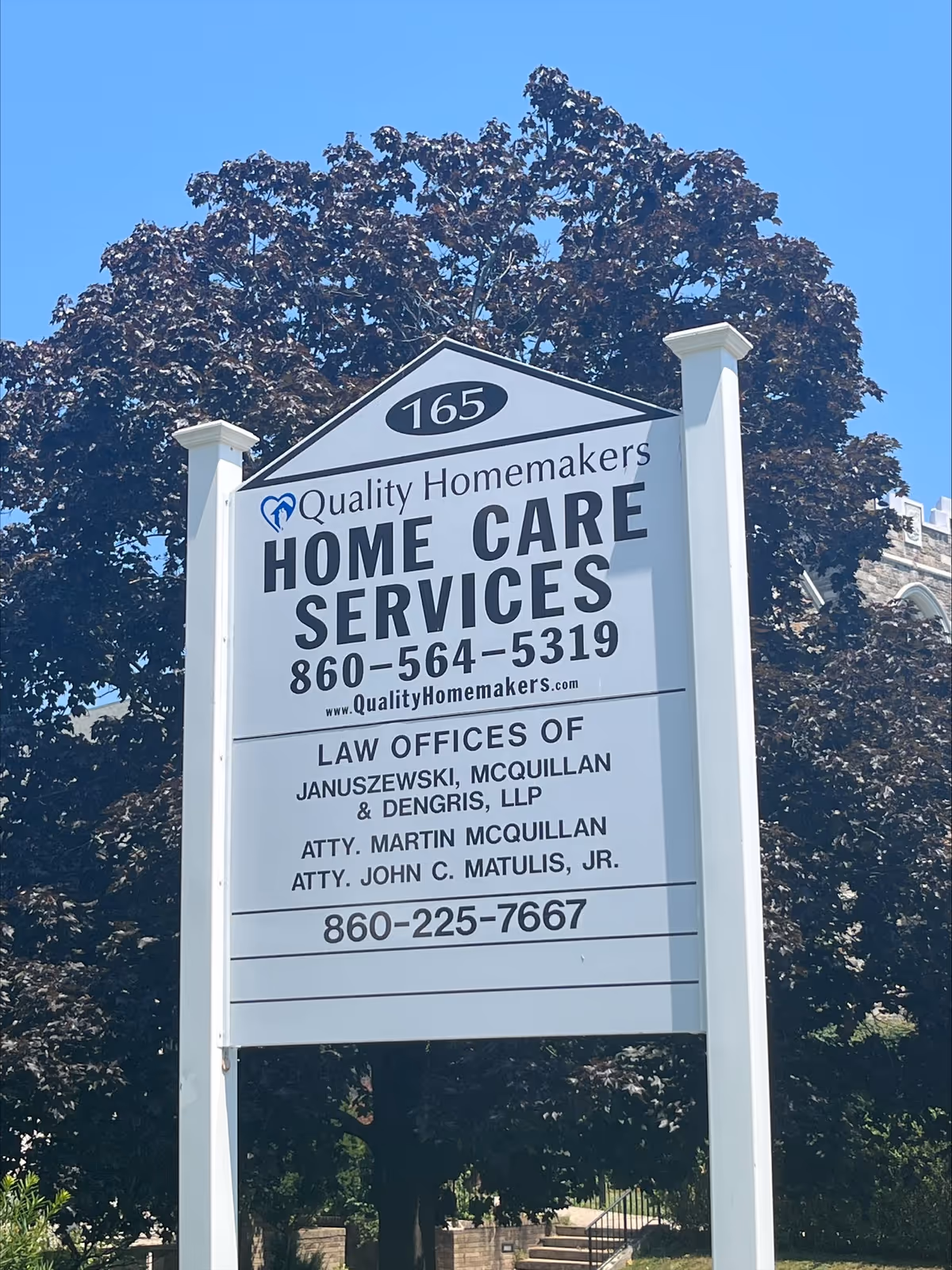 Outdoor sign for Quality Homemakers Home Care Services with phone numbers and law offices.