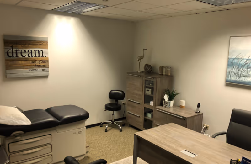 Examination room in a senior facility with chair, desk, and storage cabinets.