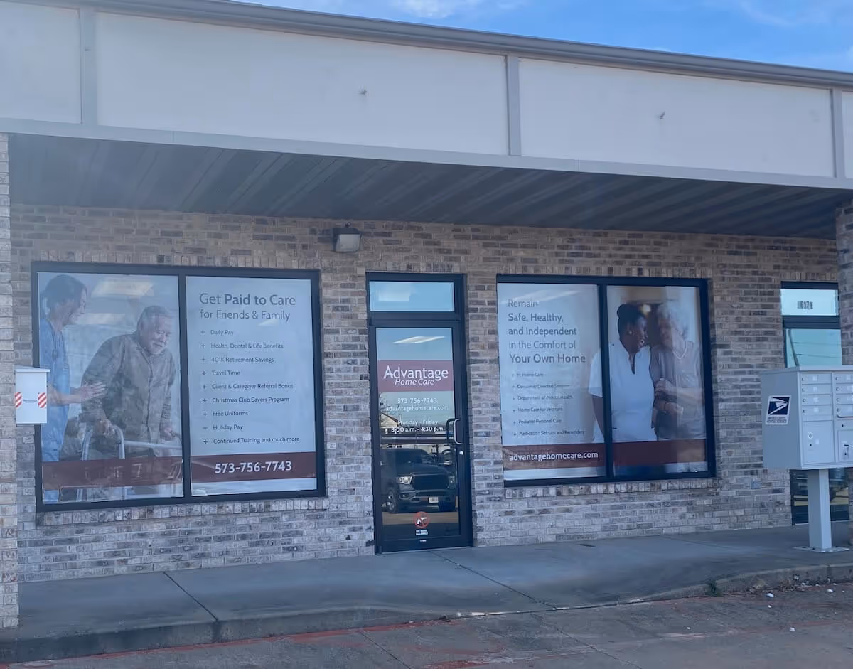 Exterior view of Advantage Home Care storefront with large poster windows and entrance.