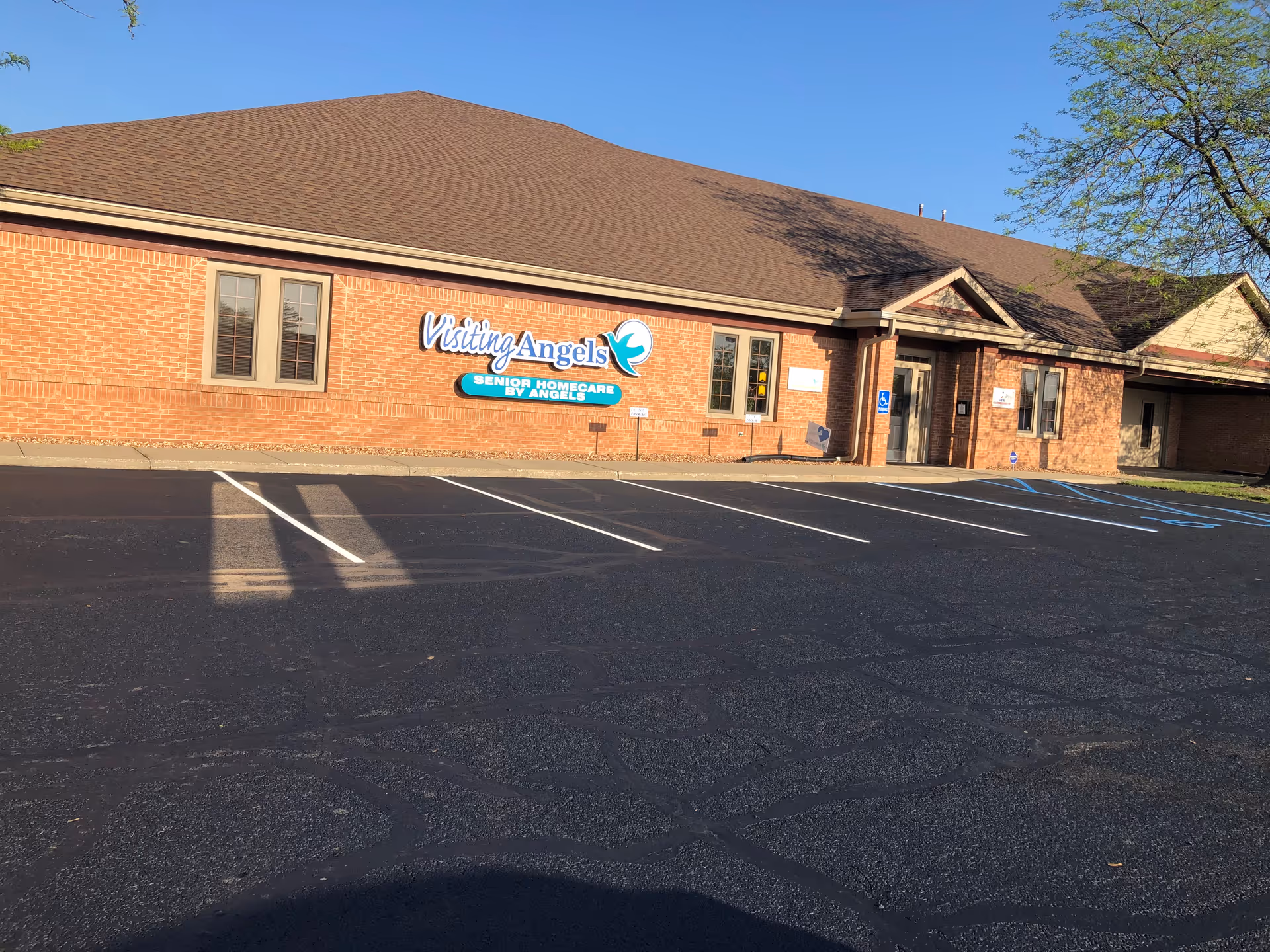 Front exterior of Visiting Angels Senior Homecare building with parking lot.