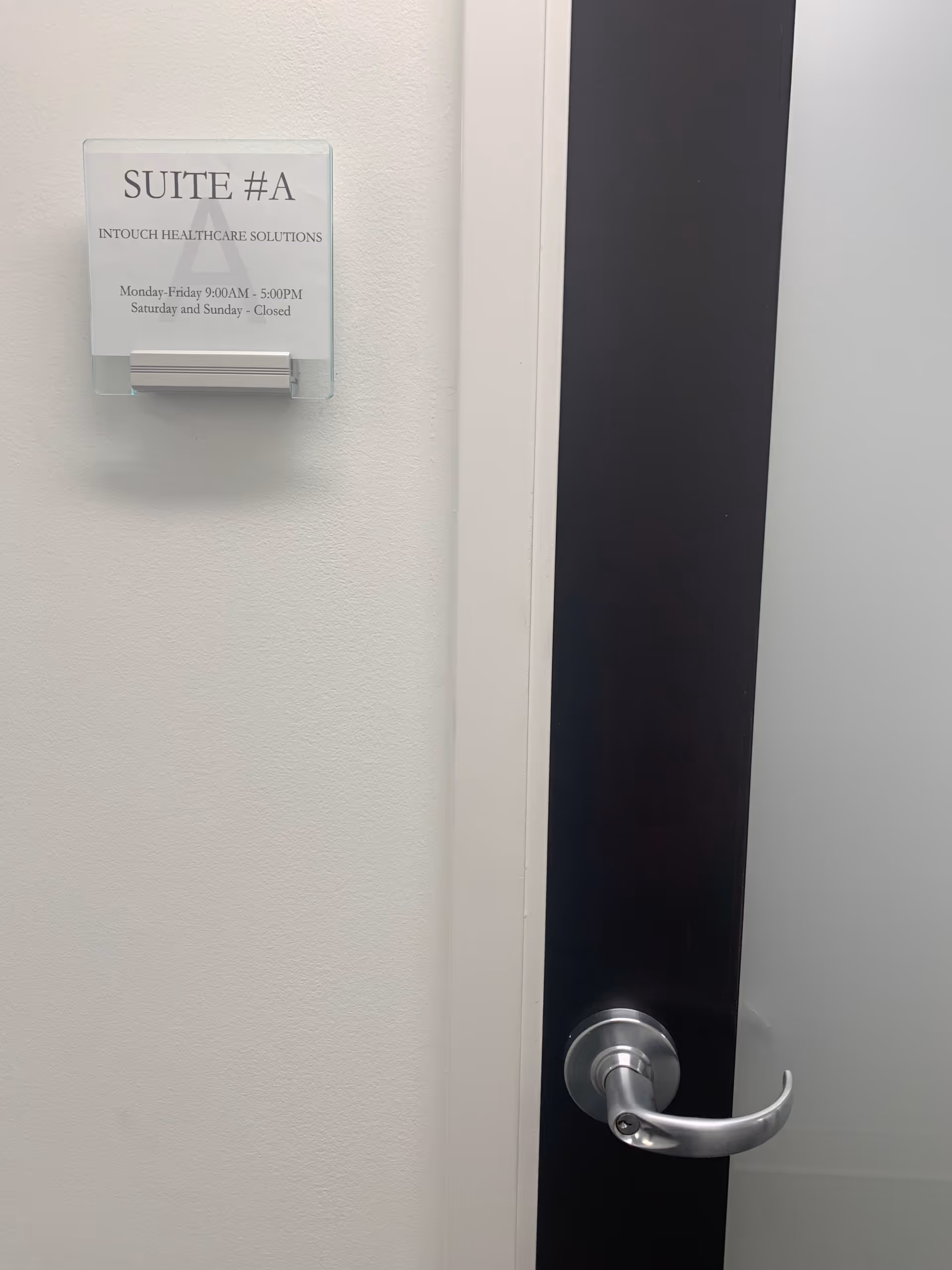 A doorway with a Suite A sign and a silver door handle