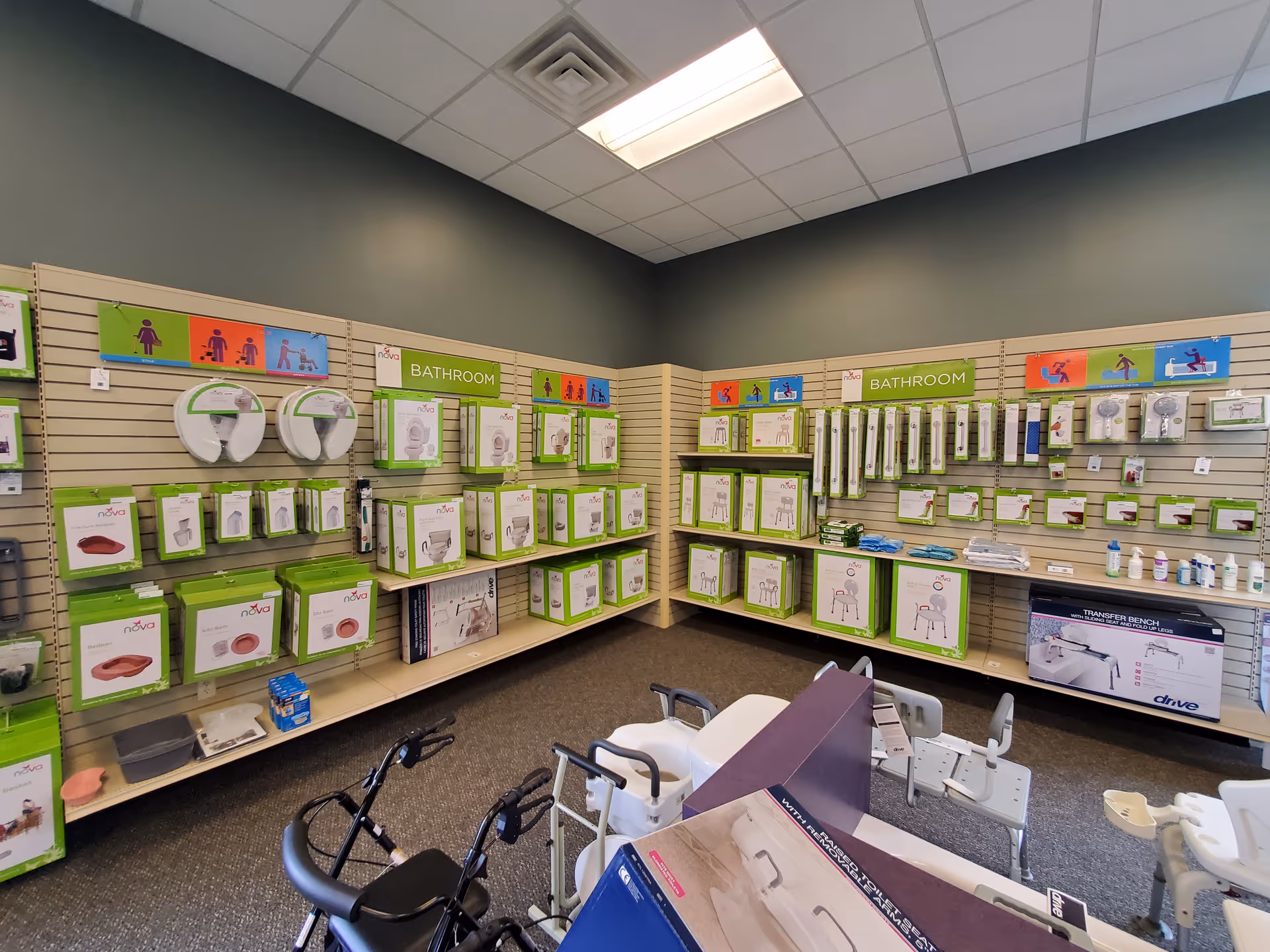 Interior medical supply showroom with green-labeled bathroom products displayed on wall shelves.