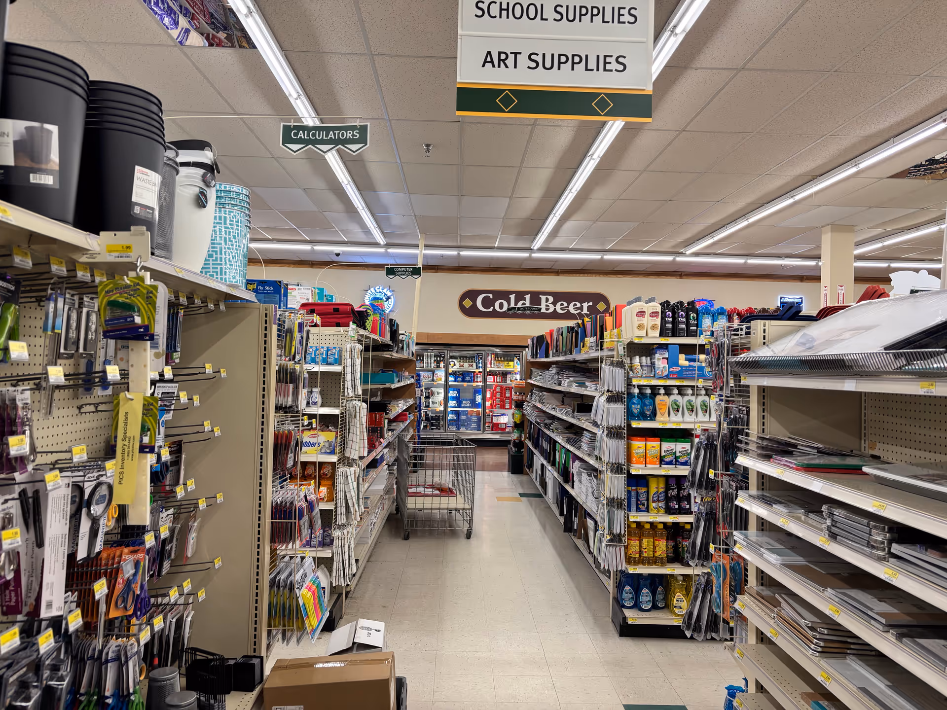 Aisle of merchandise shelves and overhead signs inside Discount Drug Mart